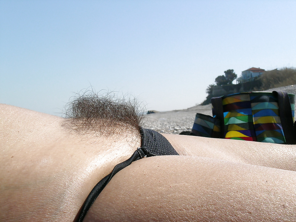 Женщина с бритым лобком переодевается на пляже