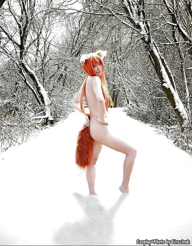 Рыжая девушка позирует голышом в снегу
