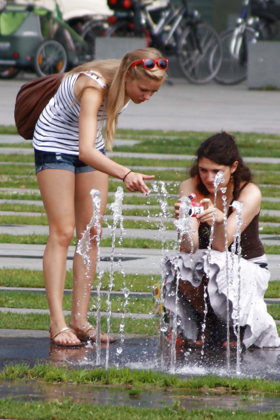 two sexy and young girls takes photos on a fountain adult photos